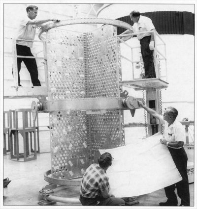 Photo of Technicians at work on a piece of test hardware for the Apollo Telescope.