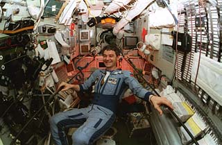 Mir-22 commander Valeri Korzun smiles for the camera while at the central post of the Base Block module. 