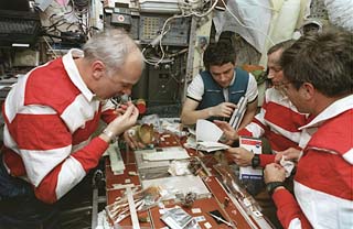 Mission specialist Tom Akers joins Blaha and Korzun while Readdy finishes his meal in the Mir space station Base Block. 