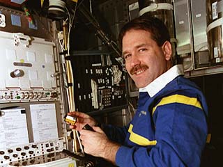 STS-81 mission specialist John Grunsfeld reloads film into a camera used to record experiments in the Biorack experiment, which is located in the Spacehab module. 