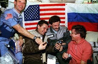 Delivering the gift of portable flashlights to the Mir-22 crew was mission specialist Jerry Linenger (left) and John Blaha (red shirt).