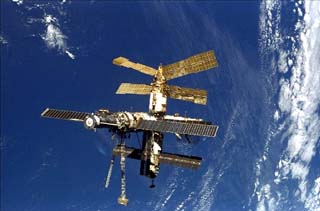 Mir space station taken by the crew of the STS-86 orbiter Atlantis including full Mir over cloudy Earth.