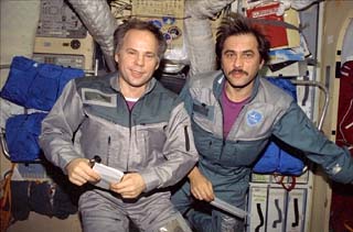 Mir-24 commander Anatoly Solovyev (left) and flight engineer Pavel Vinogradov pose for photos in the Mir space station Base Block module. 