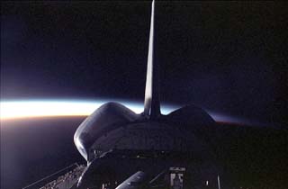 View of the STS-86 orbiter Atlantis's tail and payload bay during a sunrise. 