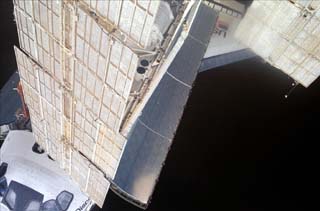 The orbiter payload bay mostly blocked by Mir Space Station solar array. 