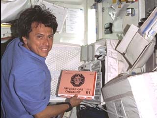 STS-91 Mission Specialist Franklin Chang-Diaz works with the Alpha Magnetic Spectrometer (AMS) computers in the orbiter middeck. 