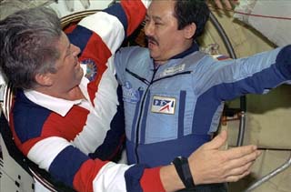 Mir-25 commander Talgat Musabayev (right) greets Mission Specialist Valery Ryumin at the docking module hatch