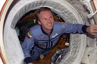 Astronaut Andy Thomas floats through the docking module hatch into the shuttle airlock. 