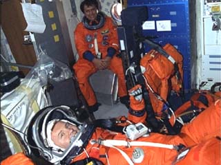 Post landing view of launch entry suited crewmembers at ease in the middeck. Mission Specialist Franklin Chang-Diaz sits at the middeck hatch. Mission Specialist Andrew Thomas waits lying down. 