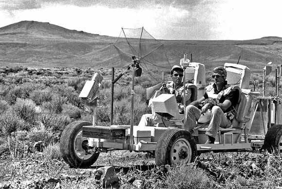 Photo of two men in the California desert driving a simulator of the Lunar Rover
