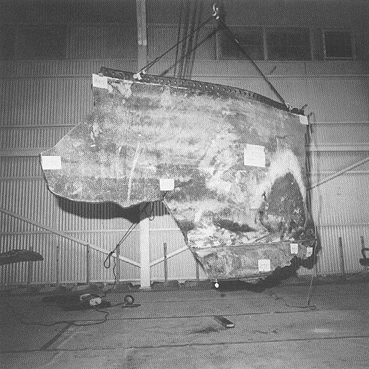 Photograph 3. Exterior View of Inverted Piece of RH SRM SSC No. 712. Note Burned-Out Area in Lower Right Corner.